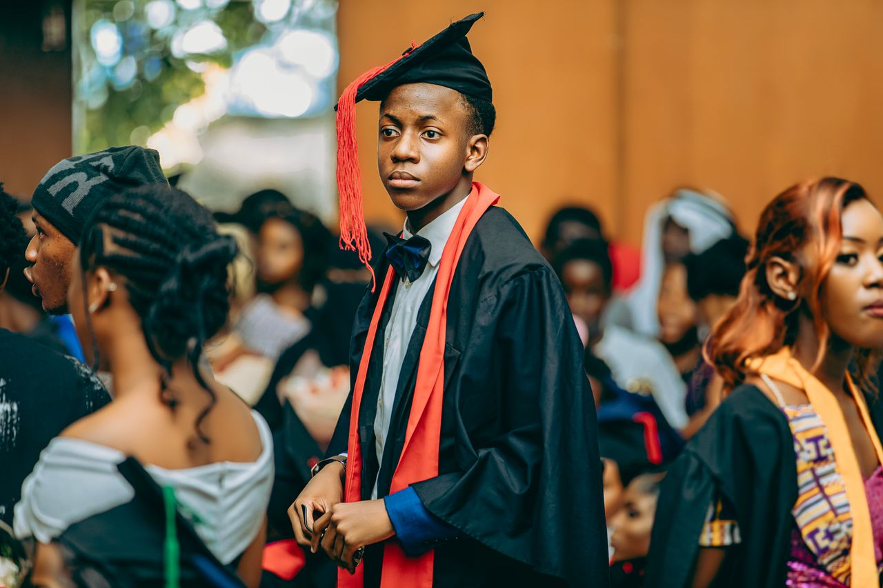 Services Group of students celebrating graduation, wearing gowns and caps at a ceremony.