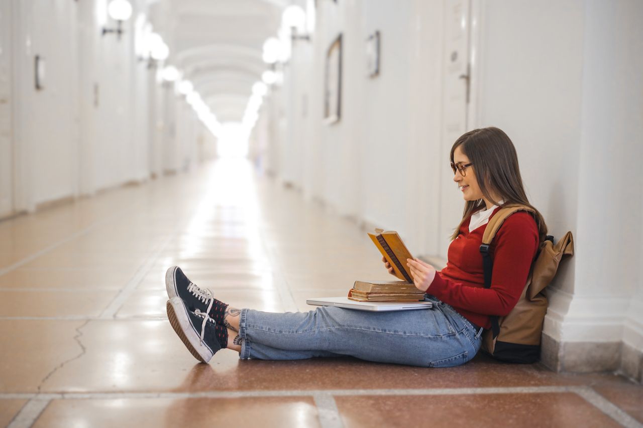 Crafting Captivating Headlines: Your awesome post title goes here A young woman in casual attire sits reading in a well-lit hallway.